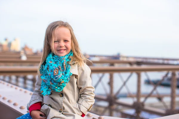 Søt liten jente som sitter ved Brooklyn Bridge – stockfoto