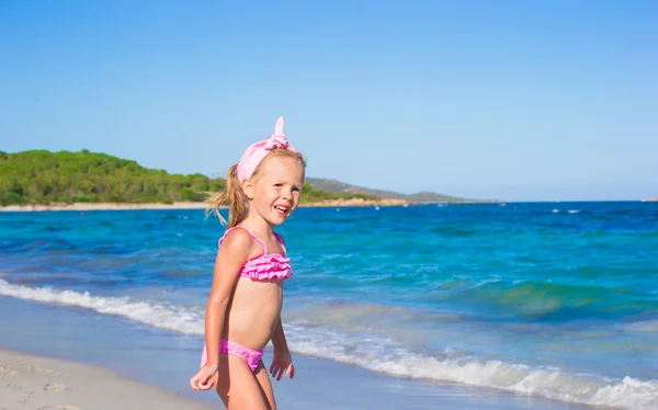 Adorable little girl have fun in shallow water at tropical beach — Stock Photo, Image