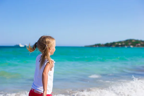 Entzückendes kleines Mädchen, das während des tropischen Strandurlaubs Spaß hat — Stockfoto