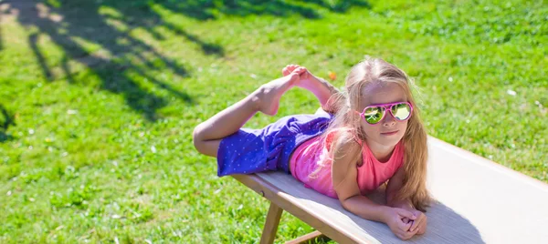 Schattig meisje op strand ligstoel buitenshuis — Stockfoto
