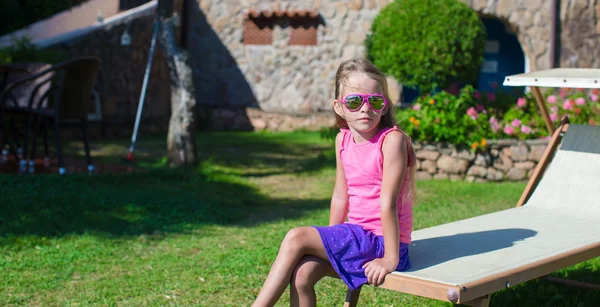 Schattig meisje op strand ligstoel buitenshuis — Stockfoto