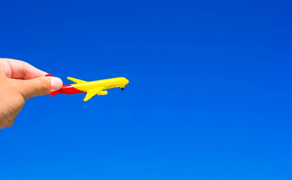 Petit avion dans les mains sur fond de ciel bleu — Photo