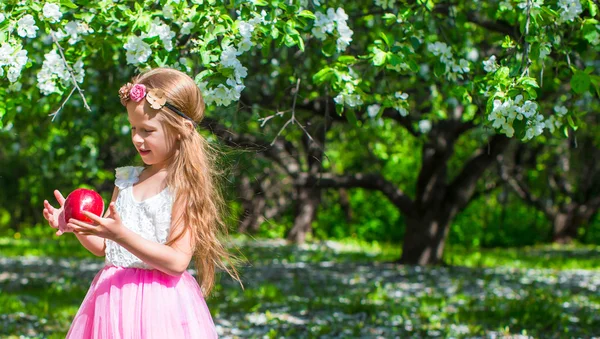 Menina adorável pequena feliz no jardim de árvore de maçã florescente — Fotografia de Stock