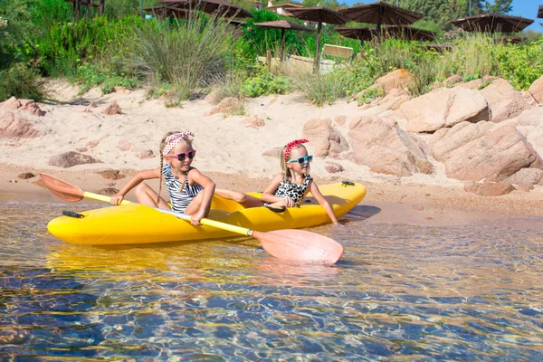 Piccole ragazze adorabili che si godono il kayak sul kayak giallo — Foto Stock