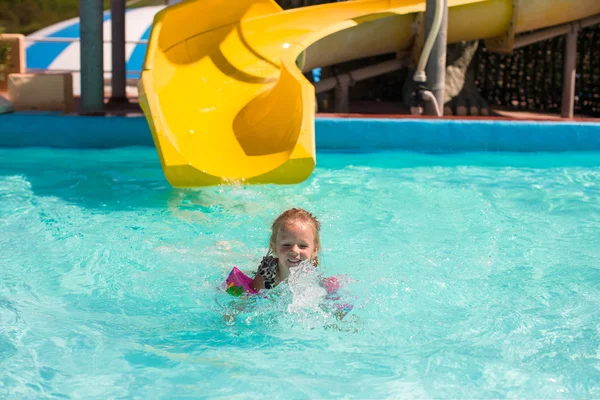 Bambina sullo scivolo d'acqua all'aquapark durante le vacanze estive — Foto Stock