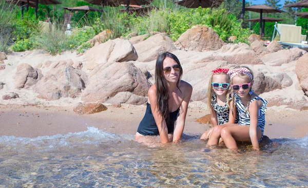 Meninas pequenas e mãe feliz durante as férias na praia — Fotografia de Stock