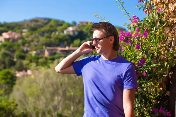 Ung man talar i mobiltelefon utomhus — Stockfoto