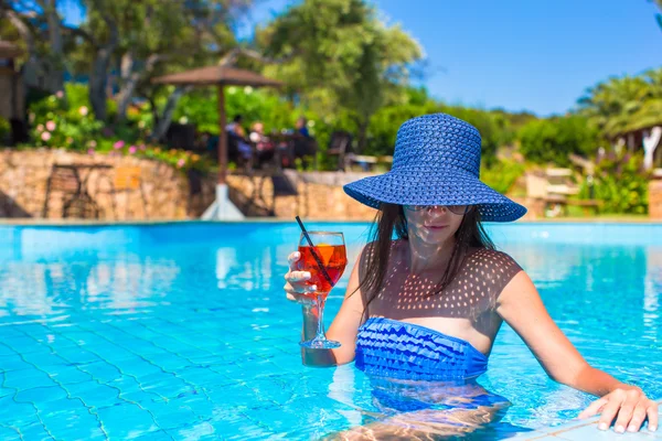 Bela jovem mulher relaxante na piscina — Fotografia de Stock