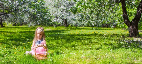 Entzückendes kleines Mädchen hat Spaß im blühenden Apfelbaumgarten im Mai — Stockfoto