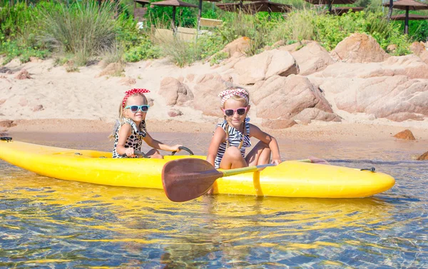 Niñas adorables disfrutando de kayak en kayak amarillo —  Fotos de Stock