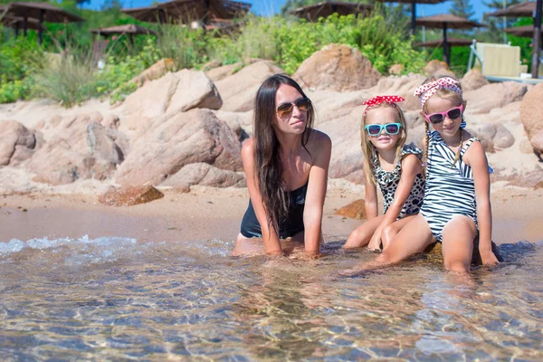 Μικρά αξιολάτρευτο κορίτσια και ευτυχισμένη μητέρα κατά τη διάρκεια του διακοπές στην παραλία — Φωτογραφία Αρχείου