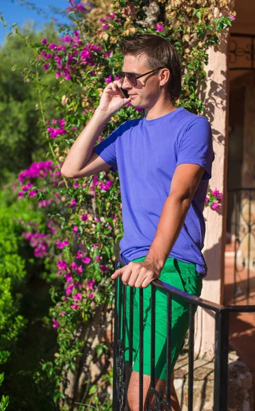 Ung man talar i mobiltelefon utomhus — Stockfoto