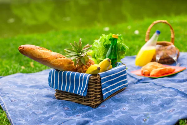 Picknickkorb mit Früchten, Brot und einer Flasche Weißwein — Stockfoto