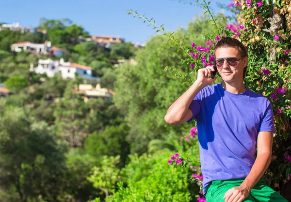 Ung man talar i mobiltelefon utomhus — Stockfoto