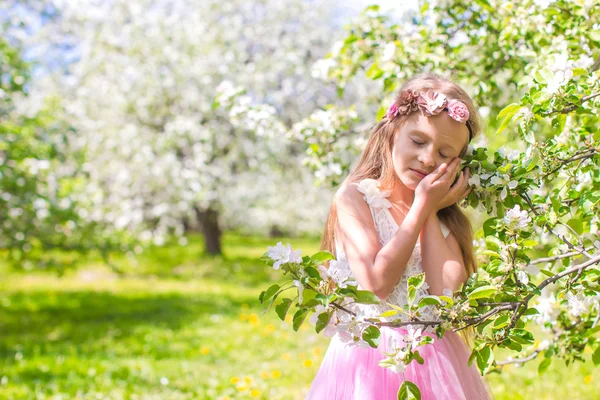 Menina adorável pequena feliz no jardim de maçã florescente — Fotografia de Stock