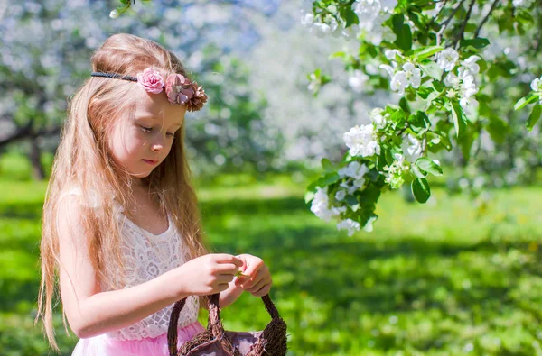 Menina adorável pequena feliz no jardim de árvore de maçã florescente — Fotografia de Stock