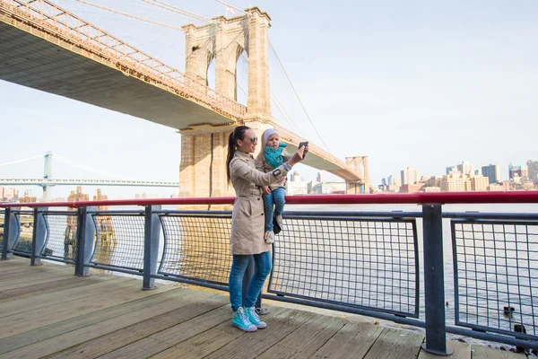 Moeder en schattig dochtertje fotograferen zelf op achtergrond van Brooklyn Bridge — Stockfoto