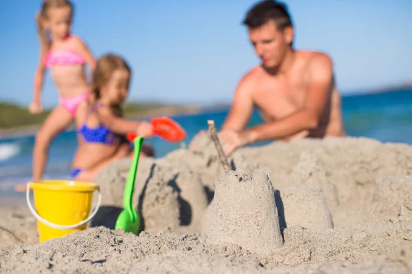 Отец и очаровательная маленькая дочь играют с пляжными игрушками во время тропических каникул — стоковое фото