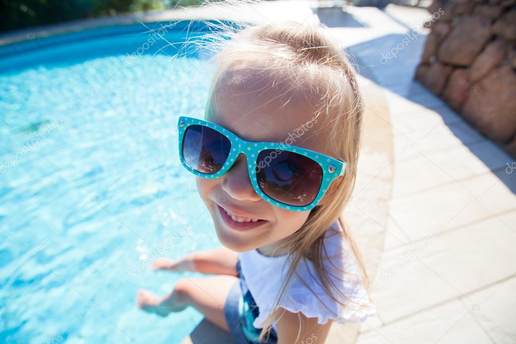 Adorable little girl have fun near pool outdoors