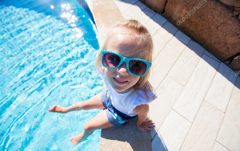 Adorable little girl have fun near pool outdoors
