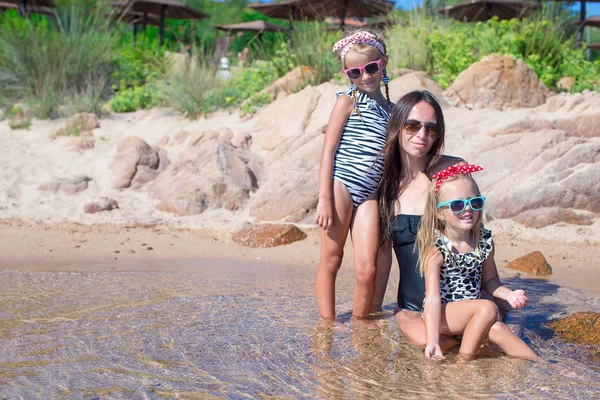 Weinig schattige meisjes en gelukkig moeder tijdens strandvakantie — Stockfoto