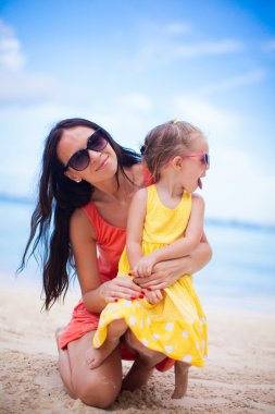 Sevimli küçük kız ve tropikal plaj tatil sırasında mutlu anne