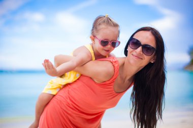 Sevimli küçük kız ve tropikal plaj tatil sırasında mutlu anne