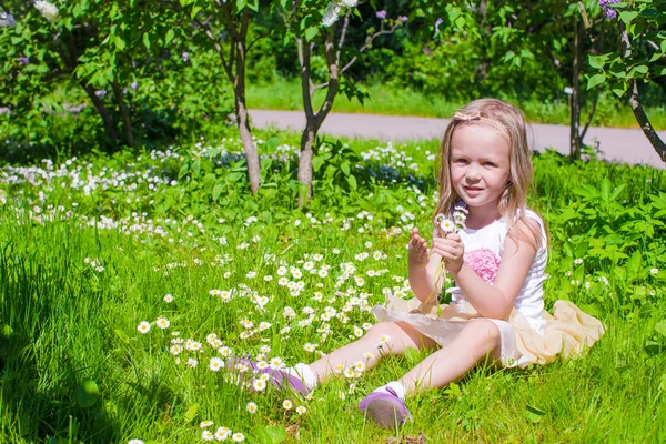 Niña adorable disfrutando de un hermoso día en el jardín floreciente —  Fotos de Stock