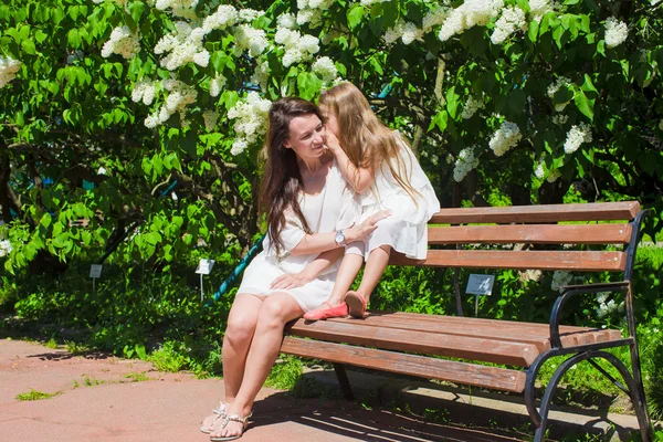 Glad mamma och bedårande tjej njuter av varm dag i lummig trädgård — Stockfoto