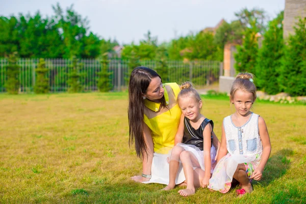 Matka i dzieci siedząc na zewnątrz w piękne letnie park — Zdjęcie stockowe