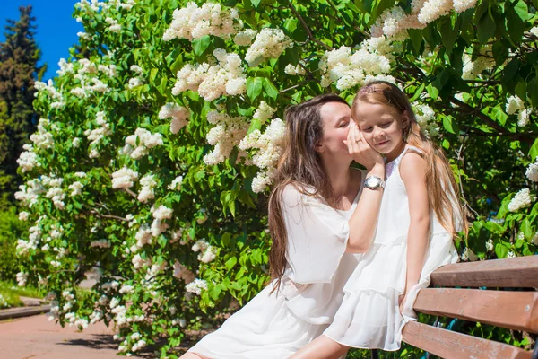 Ευτυχισμένη μητέρα και αξιολάτρευτο κορίτσι απολαμβάνει ζεστή μέρα στον καταπράσινο κήπο — Φωτογραφία Αρχείου