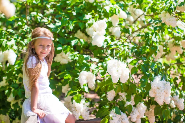 Adorable happy little girl in flower blossoming garden — Stock Photo, Image