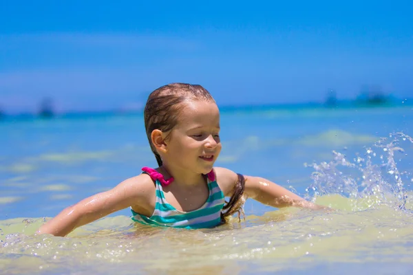 Szczęśliwa dziewczynka o zabawy, pływanie i skoki w płytkiej wodzie — Zdjęcie stockowe