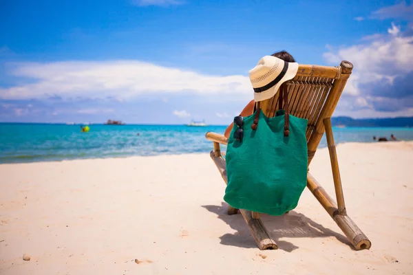 Hombre joven relajándose en silla de madera en la playa de arena blanca — Foto de Stock
