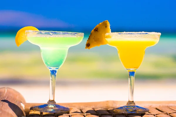 Two tasty alcoholic cocktails on background of turquoise sea — Stock Photo, Image