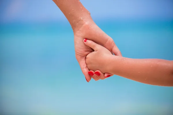 Trust family hands of child girl and mother on white beach — Stock Photo, Image