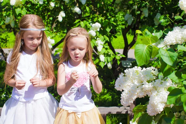 Kleine entzückende Mädchen genießen schönen Tag im blühenden Garten — Stockfoto