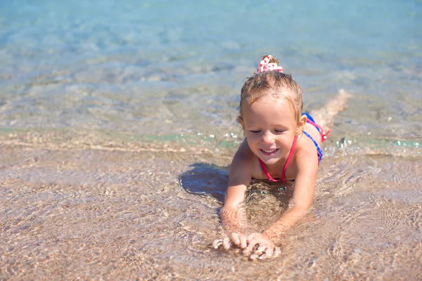 愛らしい少女熱帯ビーチで浅瀬で楽しい時を過す — ストック写真