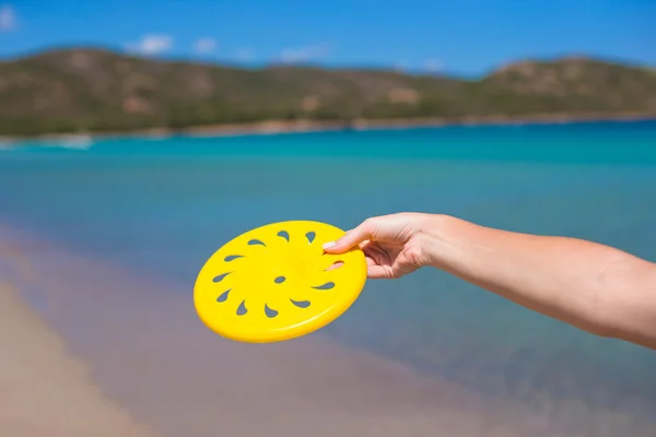 Close-up van gele frisbee op de achtergrond van de turquoise zee — Stockfoto