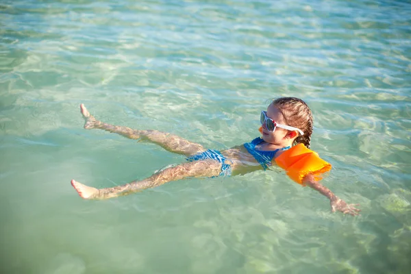 Pequena menina feliz em maiô se divertindo em mar claro — Fotografia de Stock