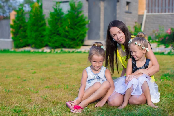 Matka i dzieci siedząc na zewnątrz w piękne letnie park — Zdjęcie stockowe