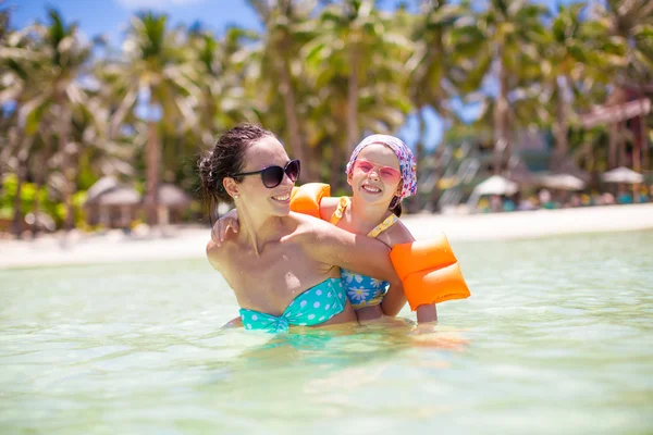 Urocza mała dziewczynka i szczęśliwa mama podczas wakacji na tropikalnej plaży — Zdjęcie stockowe