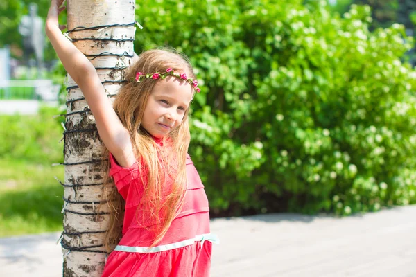A virágokat a kertben aranyos kislány portréja — Stock Fotó