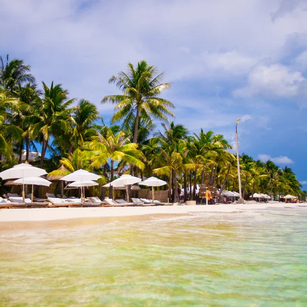 Plážová lehátka a slunečníky na exotické tropické pláži — Stock fotografie