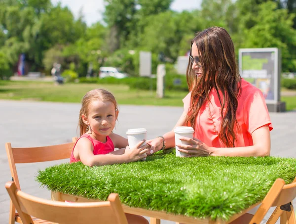 Jeune mère et sa petite fille au café extérieur le jour chaud — Photo