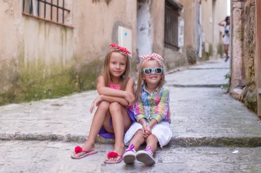 Adorable little girls outdoors in European city clipart