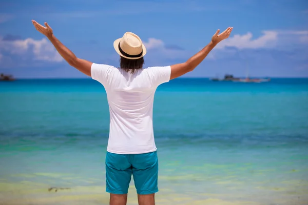 Happy young man in casual white top bright beach background — Stock Photo, Image