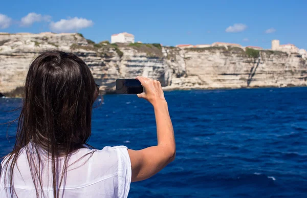 Chica tomando fotos en un teléfono en Bonifacio, Córcega, Francia —  Fotos de Stock