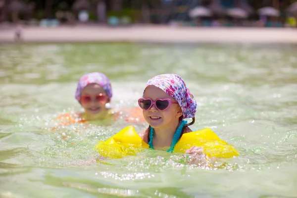 Schattige kleine meisjes zwemmen in de heldere zee — Stockfoto