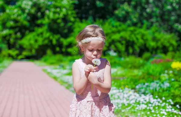 Petite fille souffler un pissenlit en plein air — Photo